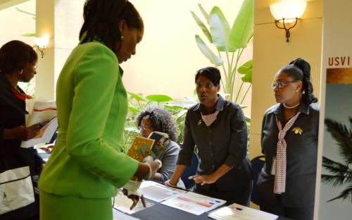 Acting Director of Lending Monique T. Samuel (second from the right) talks to conference attendees about the lending programs of the VIEDA alongside Loan Assistant Charlene Gerard (right) at the display table of the VIEDA.